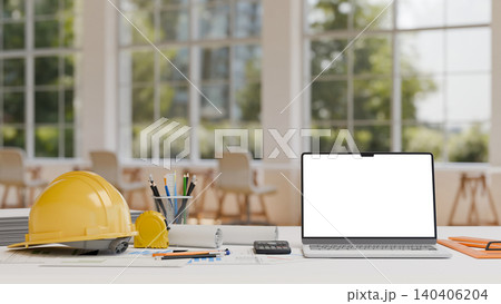 Modern engineering desk with blank laptop screen safety helmet and drafting equipment in office 140406204