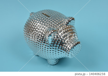 Shiny silver textured piggy bank on a blue background Shiny silver textured piggy bank on a blue background 140406238