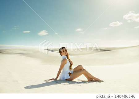 Portrait, fashion and woman with vacation, sand and weekend break with dune, relax and getaway trip. Blue sky, person and girl with holiday and pose with adventure and outdoor with nature and desert 140406546