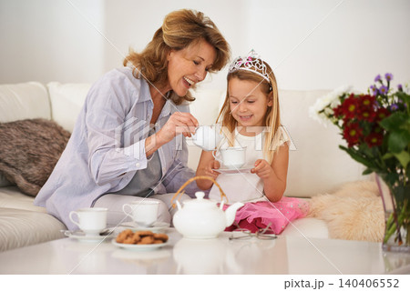 Grandmother, child and smile for tea party in living room with bonding, playing and breakfast or brunch at home. Excited senior woman, family and girl pouring drink in cup for princess game or fun Grandmother, child and smile for tea party in living room with bonding, playing and breakfast or brunch at home. Excited senior woman, family and girl pouring drink in cup for princess game or fun 140406552