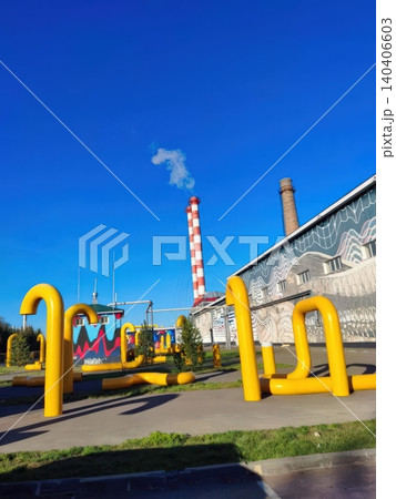 Urban public sculpture with vibrant yellow installations against industrial background 140406603