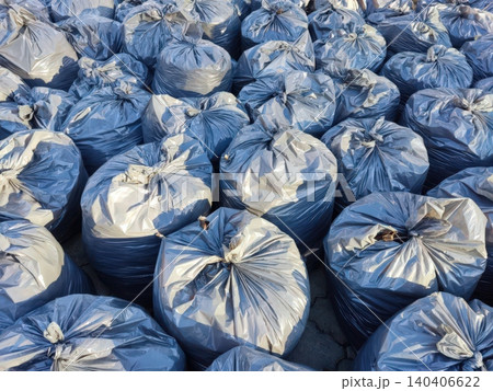 Heap of blue garbage bags neatly arranged outdoors in sunlight Heap of blue garbage bags neatly arranged outdoors in sunlight 140406622
