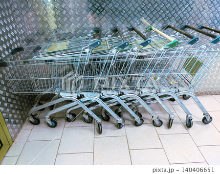 Row of empty shopping carts in a tiled store aisle for retail and consumerism concept Row of empty shopping carts in a tiled store aisle for retail and consumerism concept 140406651