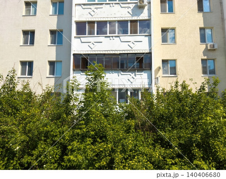 Urban apartment building facade with greenery in front on a sunny day Urban apartment building facade with greenery in front on a sunny day 140406680