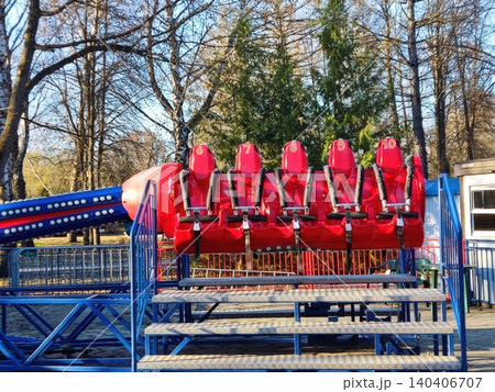 Vibrant red amusement park ride against a background of winter trees Vibrant red amusement park ride against a background of winter trees 140406707