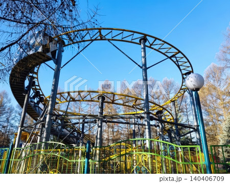 Vibrant roller coaster in a bright autumn amusement park setting 140406709