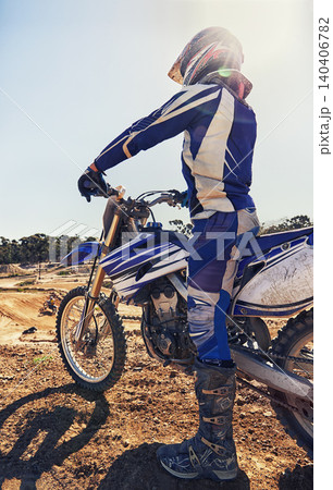 Motorcycle, extreme sports and danger with biker person outdoor, sunshine with uniform for riding on dirt track. Speed, power and risk with motorbike, transportation and adventure for adrenaline 140406782