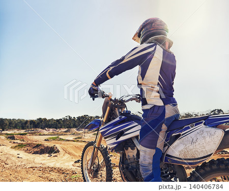 Motorbike, sports and danger with back view of biker person outdoor, sunl with uniform for riding on dirt track. Speed, power and risk with motorcycle, transportation and adventure for adrenaline Motorbike, sports and danger with back view of biker person outdoor, sunl with uniform for riding on dirt track. Speed, power and risk with motorcycle, transportation and adventure for adrenaline 140406784