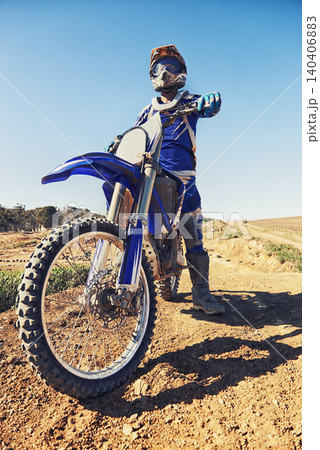 Motorcycle, sports and danger with biker person outdoor, low angle with uniform for riding on dirt track. Speed, power and risk with motorbike, transportation and adventure for adrenaline and travel 140406883