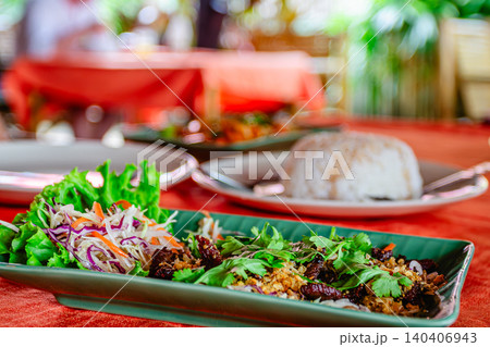 Fresh local dishes served on a vibrant table in a tropical restaurant setting Fresh local dishes served on a vibrant table in a tropical restaurant setting 140406943