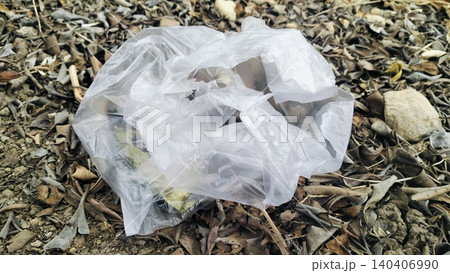 Discarded plastic bag littering on dry autumn leaves ground. Discarded plastic bag littering on dry autumn leaves ground. 140406990