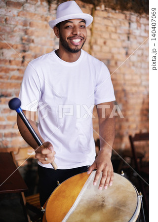 Portrait, drum or carnival with a happy man playing an instrument in a festival in Rio de Janeiro. Brazil, smile or party with a proud musician, performer or artist banging to create a beat or rhythm 140407069
