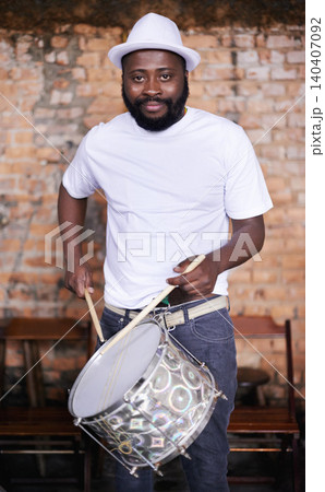 Portrait, drums or carnival with a black man playing an instrument in a festival in Rio de Janeiro. Brazil, ready or party with a male musician, performer or artist banging on a drum to create a beat Portrait, drums or carnival with a black man playing an instrument in a festival in Rio de Janeiro. Brazil, ready or party with a male musician, performer or artist banging on a drum to create a beat 140407092