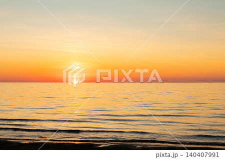 Vibrant orange sunset in the empty beach by the sea. Vibrant orange sunset in the empty beach by the sea. 140407991