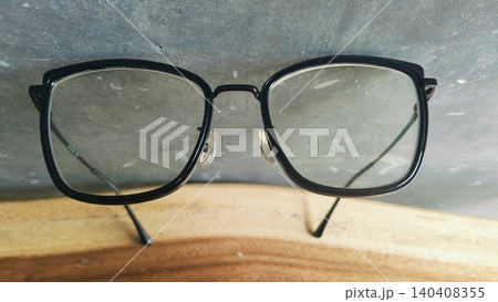 Black Frame Eyeglasses on Wooden Table Close Up 140408355