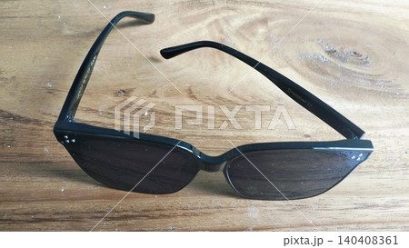 Black Oversized Sunglasses on Wooden Surface Close-Up 140408361