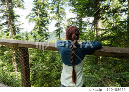 Child enjoying forest view on canopy walkway Child enjoying forest view on canopy walkway 140408653