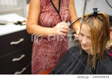 Woman getting haircut in hair salon with hairdresser Woman getting haircut in hair salon with hairdresser 140408659