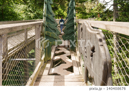 Person walking on treetop walkway in forest Person walking on treetop walkway in forest 140408676