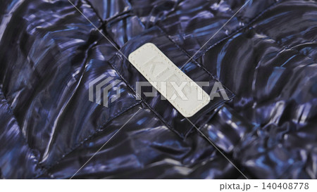 Kids navy blue puffer jacket close-up with KIDS label, illustrating children's fashion 140408778