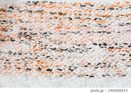 Abstract woven textile texture with white, orange and dark yarn details 140408915