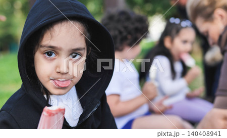 Happy little girl enjoying strawberry popsicle sticking out tongue Happy little girl enjoying strawberry popsicle sticking out tongue 140408941