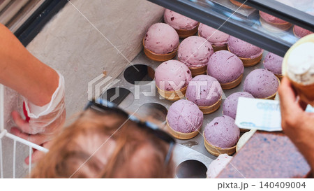 Buying refreshing berry ice cream from a street vendor in waffle cones Buying refreshing berry ice cream from a street vendor in waffle cones 140409004