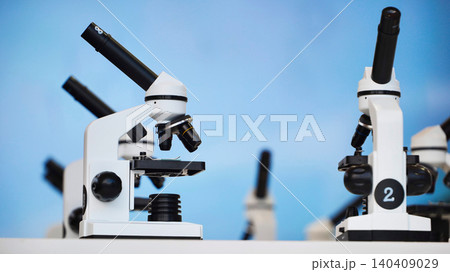 White optical microscopes on a table, researching science and medicine concepts White optical microscopes on a table, researching science and medicine concepts 140409029