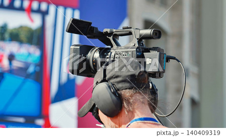 Videographer recording sport event with professional camcorder Videographer recording sport event with professional camcorder 140409319