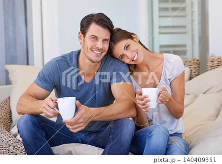 Happy couple, coffee and sofa with love for morning, bonding or weekend together at home. Face of young man and woman with smile, cup of tea or cappuccino for support, care or trust at apartment Happy couple, coffee and sofa with love for morning, bonding or weekend together at home. Face of young man and woman with smile, cup of tea or cappuccino for support, care or trust at apartment 140409351