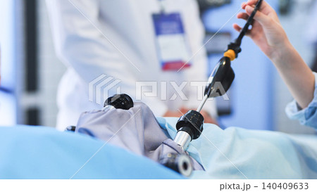 Surgeon performing laparoscopic surgery using medical technology in a modern hospital Surgeon performing laparoscopic surgery using medical technology in a modern hospital 140409633