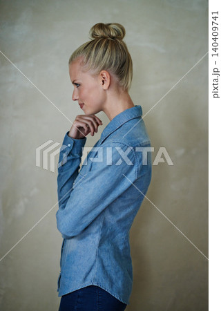 Young woman, thinking and casual fashion on a beige wall background at home for idea. Vision, profile and female person with style and apparel while relaxing in her house and planning trendy clothing 140409741