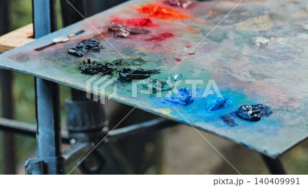 Artist's painting palette with vibrant oil paints blending, creating new colors in Moscow Artist's painting palette with vibrant oil paints blending, creating new colors in Moscow 140409991