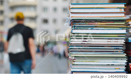 Stack of colorful books forming a tower in a city street market Stack of colorful books forming a tower in a city street market 140409992