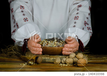 Traditional slavic holiday meal kutia is presented in wooden bowl nuts, and berries on dark background. Preserving age old traditions Traditional slavic holiday meal kutia is presented in wooden bowl nuts, and berries on dark background. Preserving age old traditions 140410398