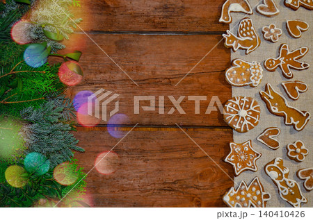 Seasonal cookies arranged in varied shapes. Icing designs showcase diverse winter shapes. Celebration and cooking concept with christmas decoration and gingerbread cookies on wooden background. 140410426