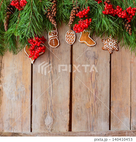 Royal icing cookies. Christmas gingerbread cookies on wooden table top view. Flat lay of Christmas gingerbread cookies on wooden background. Sprinkle accents introduce vibrant contrast. 140410453