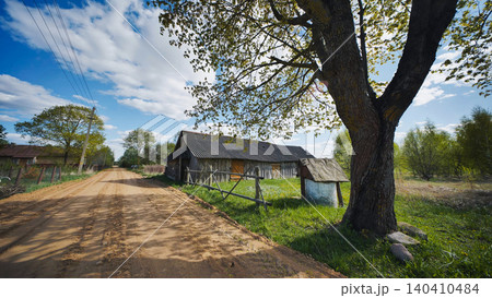 Countryside landscape showing a dirt road, old barn, and well on a sunny day Countryside landscape showing a dirt road, old barn, and well on a sunny day 140410484