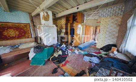 Messy living room in abandoned slavic village house with clothes scattered on floor Messy living room in abandoned slavic village house with clothes scattered on floor 140410502