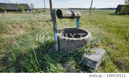 Old abandoned well with wooden roller and rope in slavic village Old abandoned well with wooden roller and rope in slavic village 140410521