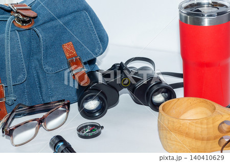 Backpack, compass, binoculars and flashlight, camping mug and thermos-a hiking kit. Backpack, compass, binoculars and flashlight, camping mug and thermos-a hiking kit. 140410629