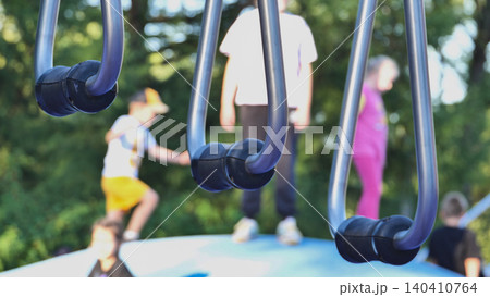 Playground metal rings for children playing and exercising outdoors during summer Playground metal rings for children playing and exercising outdoors during summer 140410764