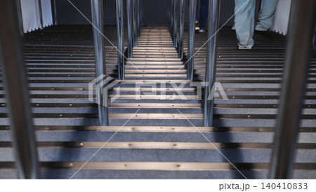 People ascending carpeted stairs at a public exhibition with a green balloon People ascending carpeted stairs at a public exhibition with a green balloon 140410833