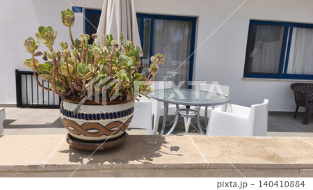 Decorative Kalanchoe tetraphylla in a ceramic pot on a sunny terrace of a Mediterranean resort. Cozy outdoor patio with modern furniture, travel, relaxation and vacation concept 140410884