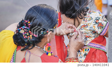 Preparing for Ganesha Chaturthi, Indian women dressing in colorful traditional clothing Preparing for Ganesha Chaturthi, Indian women dressing in colorful traditional clothing 140411041