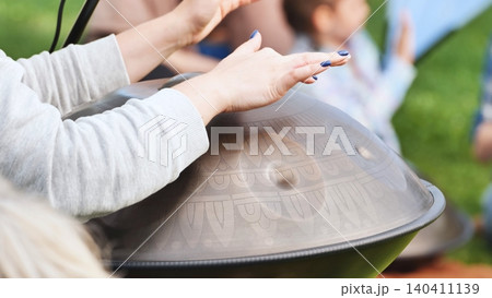 Musician playing a handpan with engraved patterns at India Day in Moscow 140411139