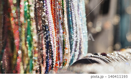 Colorful sparkling beads reflecting light and hanging in an Indian market stall 140411193