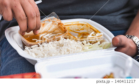 Man eating Indian takeaway food with rice and curry outdoor at India Day Moscow Man eating Indian takeaway food with rice and curry outdoor at India Day Moscow 140411217