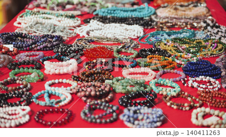 Colorful bracelets and necklaces resting on red cloth in India Colorful bracelets and necklaces resting on red cloth in India 140411263