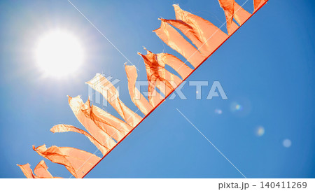 Orange flags flying at India Day celebration, bright sun and blue sky in Moscow Orange flags flying at India Day celebration, bright sun and blue sky in Moscow 140411269